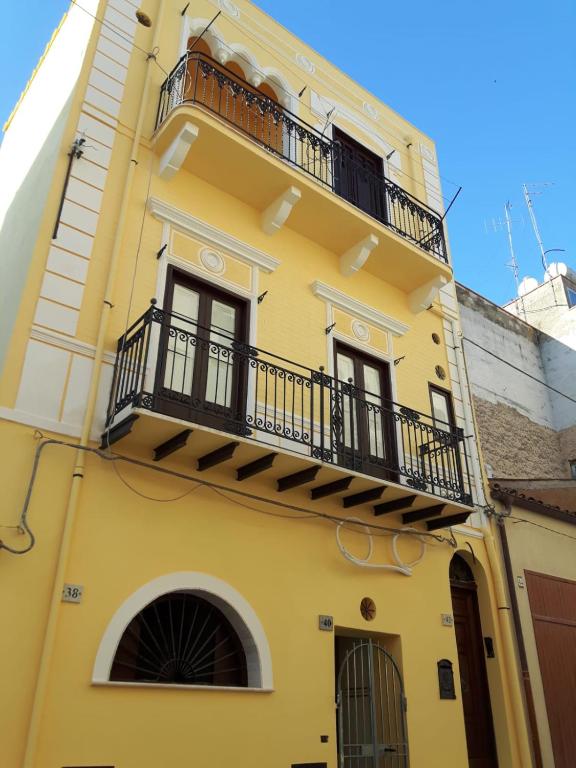 żółty budynek z balkonem w obiekcie Casa Vacanze Mannina w mieście Castellammare del Golfo