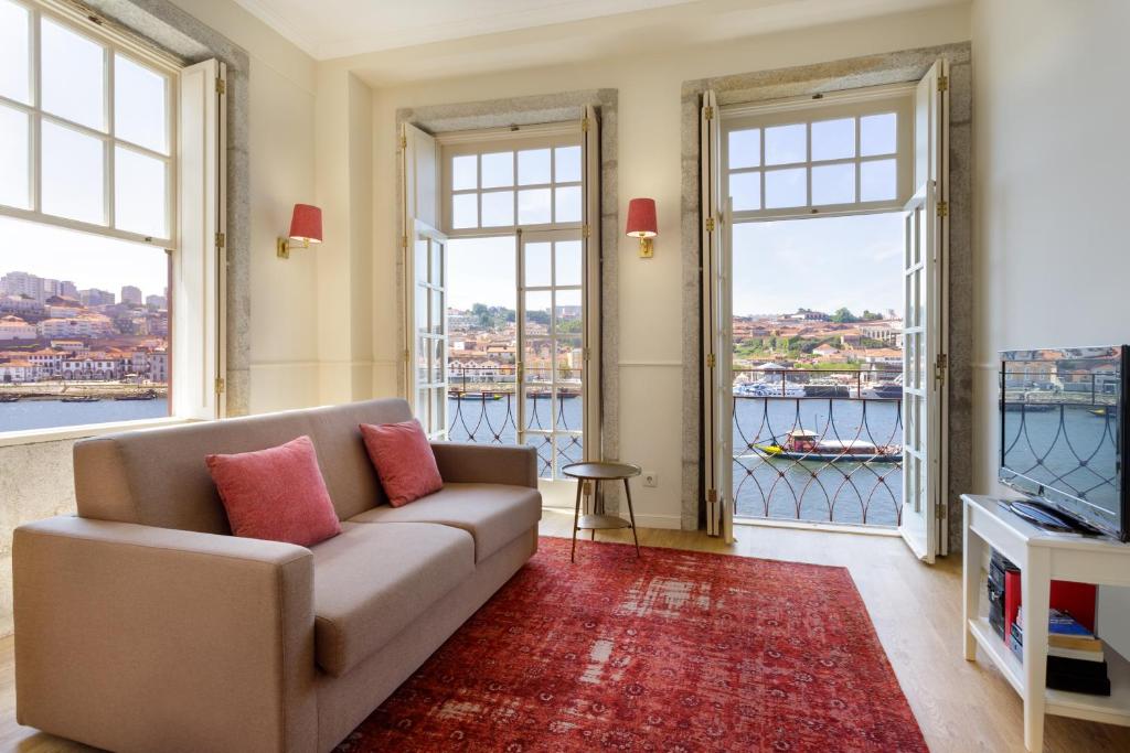 a living room with a couch and two large windows at Oporto Home - River Front in Porto