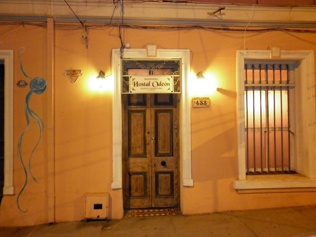 una puerta delantera de una casa con un cartel en ella en Hostal Odeón, en Valparaíso