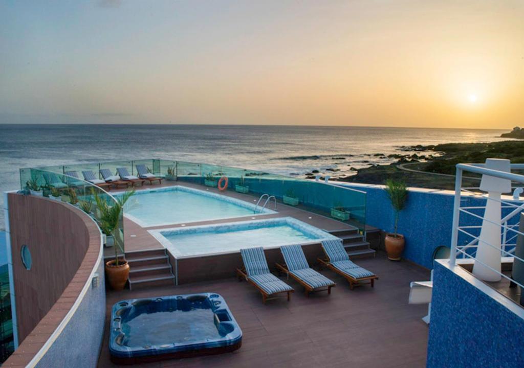 a balcony with a swimming pool and the ocean at Hotel Vip Praia in Praia