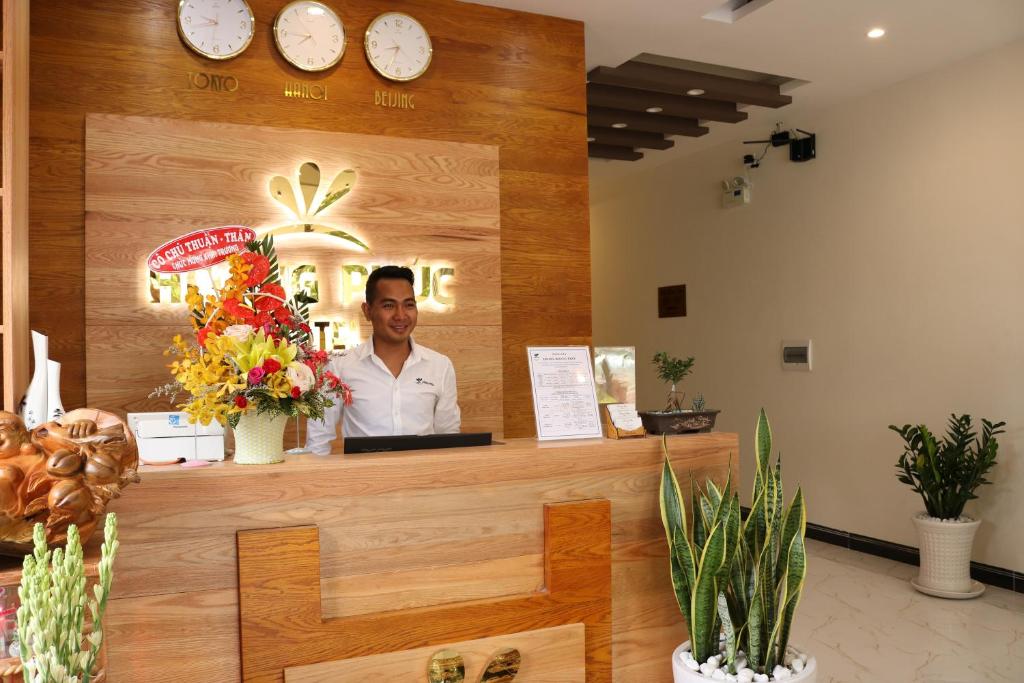 a man is standing behind the counter of a restaurant at Hoang Phuc Hotel in Thu Dau Mot