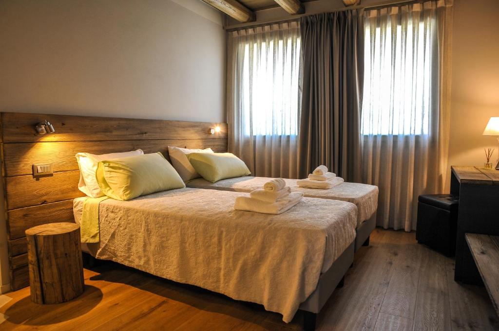 a bedroom with a large bed with towels on it at Corte Grisela Wine&Relax in Monteforte dʼAlpone