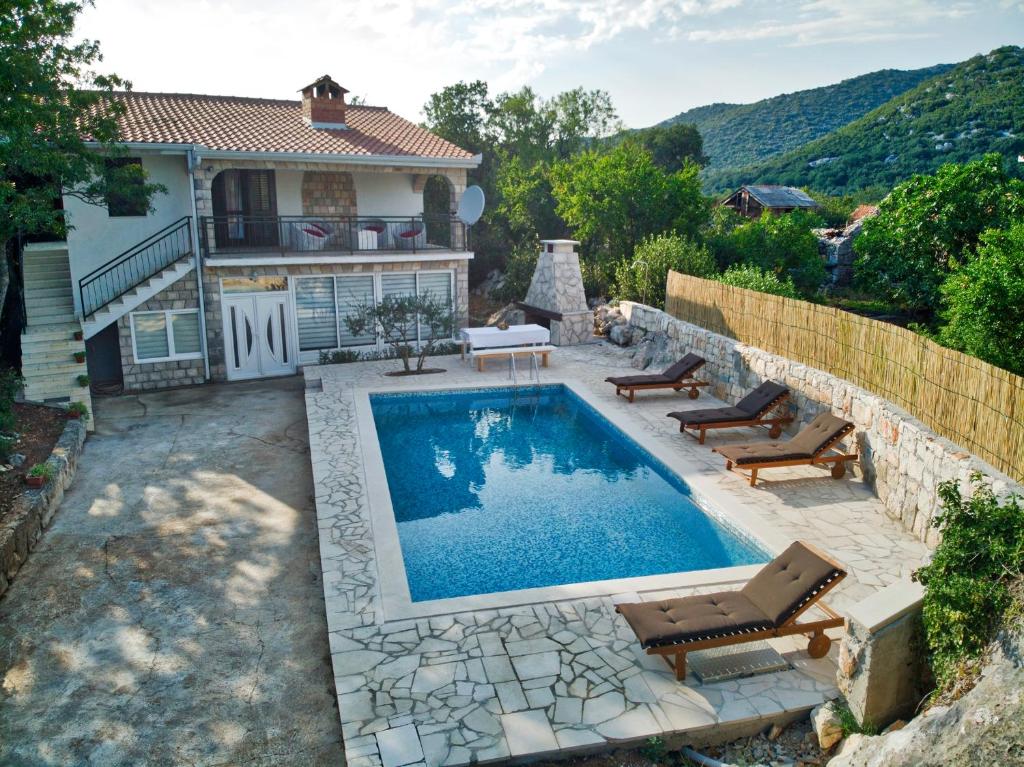 a swimming pool in front of a house at Villa Nada in Neum