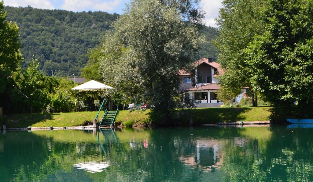 a house sitting on the shore of a lake at Amal Grand Villa in Bihać
