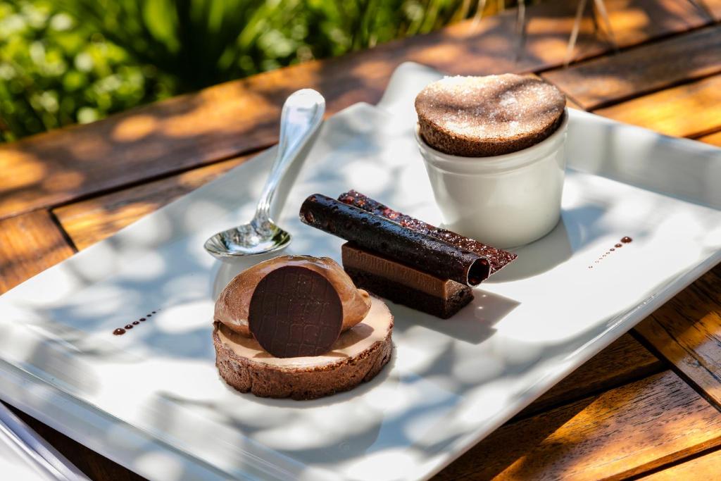 a plate with chocolate desserts and a drink on a table at Hotel Le Maquis in Porticcio