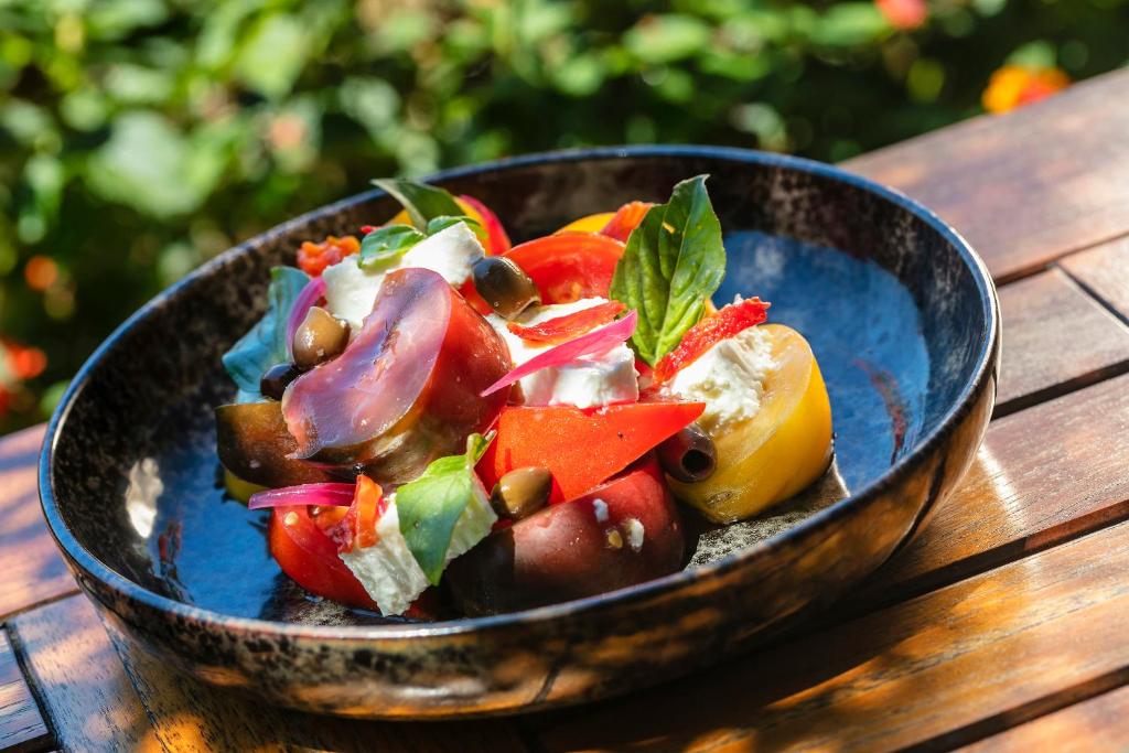 a bowl of vegetables on a wooden table at Hotel Le Maquis in Porticcio