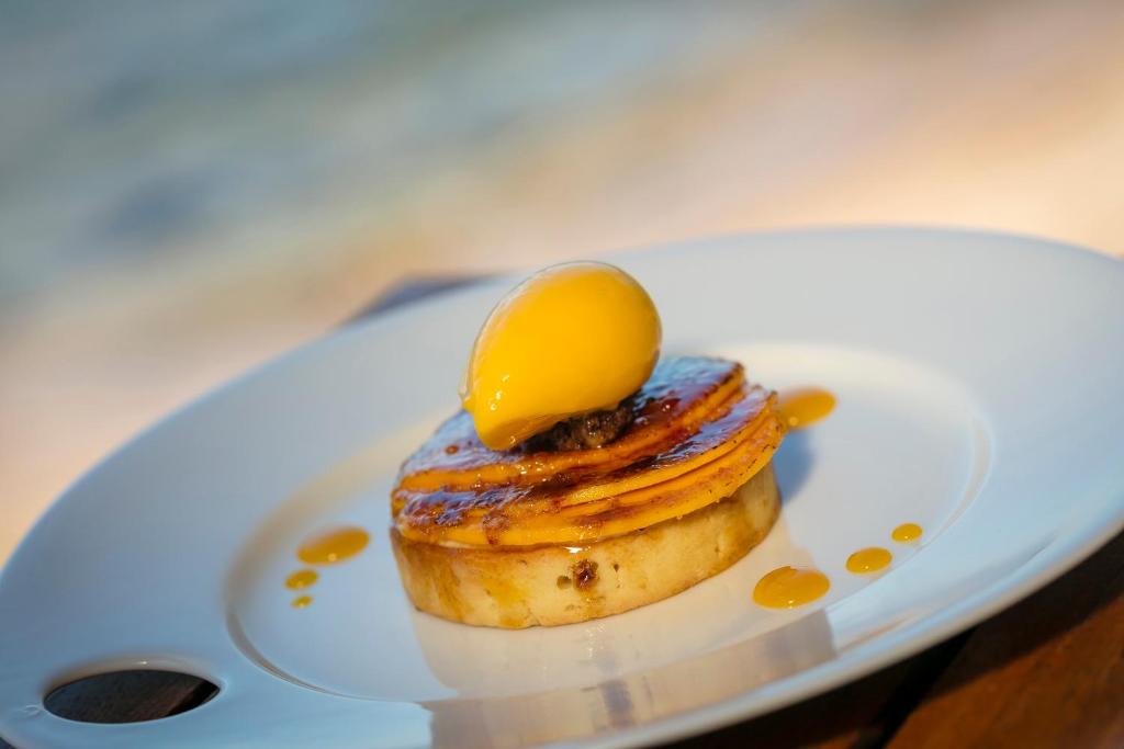 a dessert on a white plate with a lemon on top at Hotel Le Maquis in Porticcio