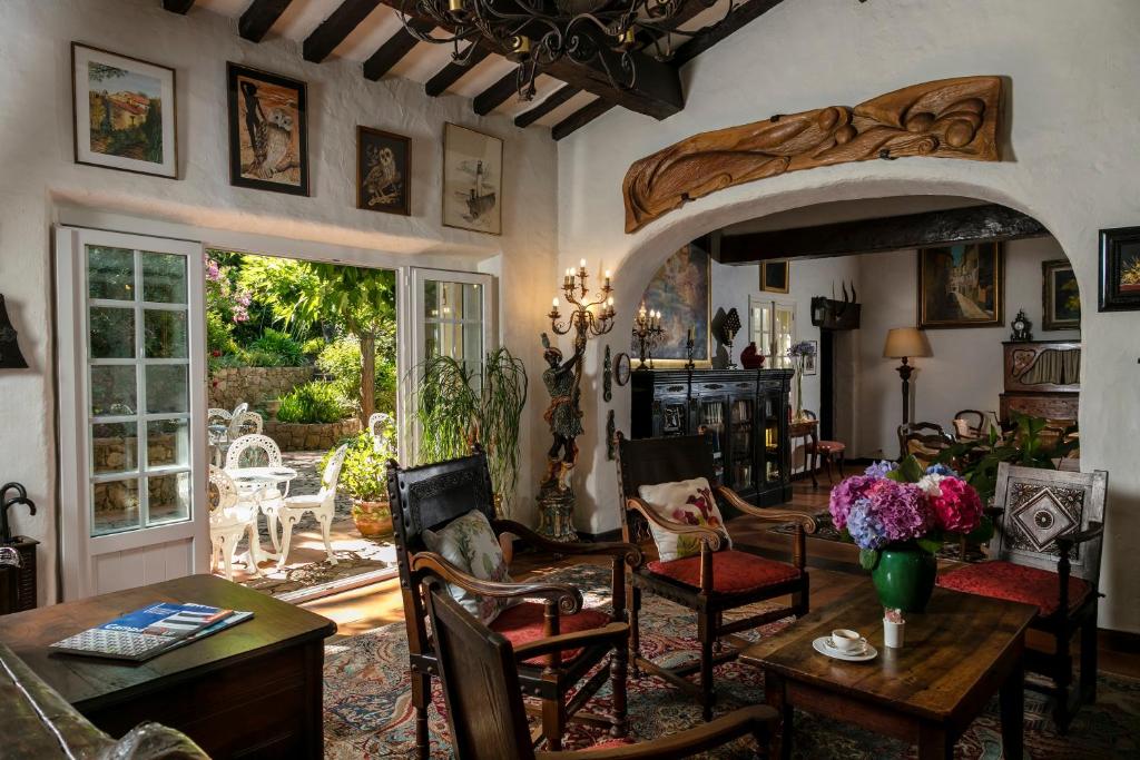 a living room with a table and chairs at Hotel Le Maquis in Porticcio