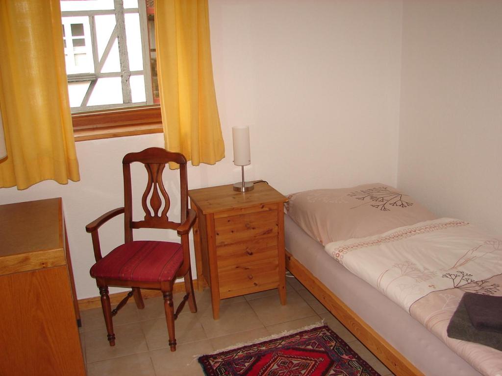 a bedroom with a chair and a bed and a window at Messezimmer Laatzen APO 2 in Hemmingen