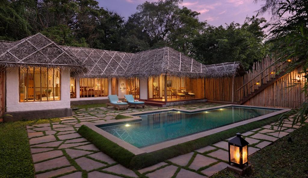 a swimming pool in the yard of a house at Evolve Back Kabini in Begūr