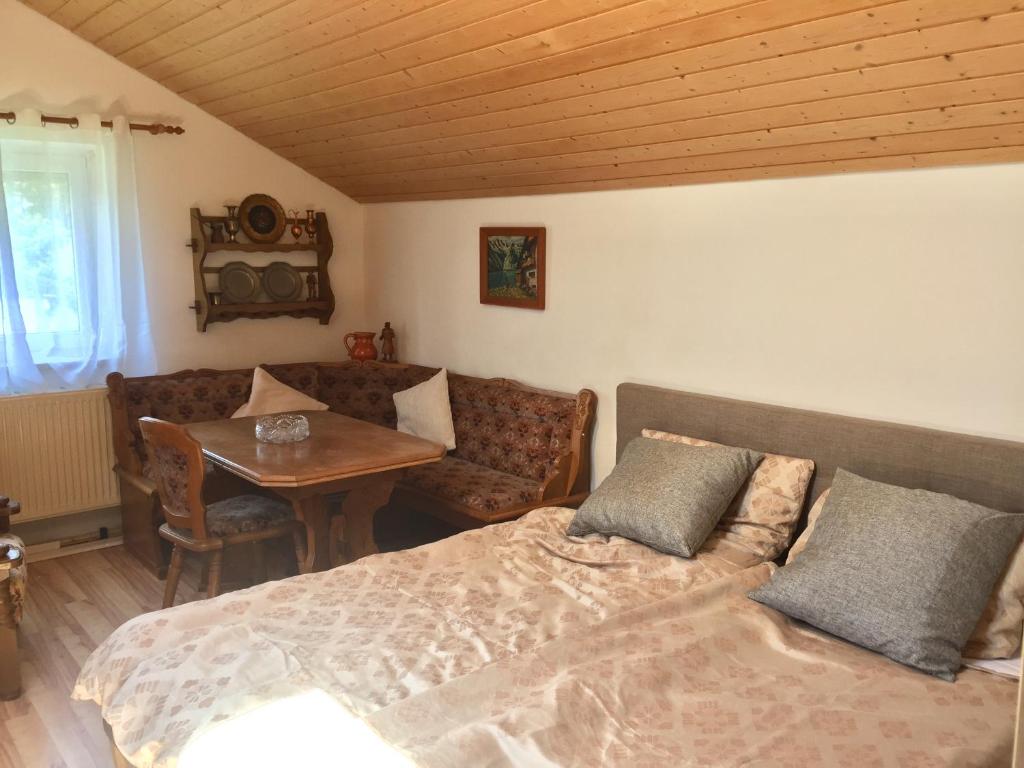 1 dormitorio con cama, mesa y sofá en Bavarian Holiday Home - A94 Autobahn, en Oberheldenstein