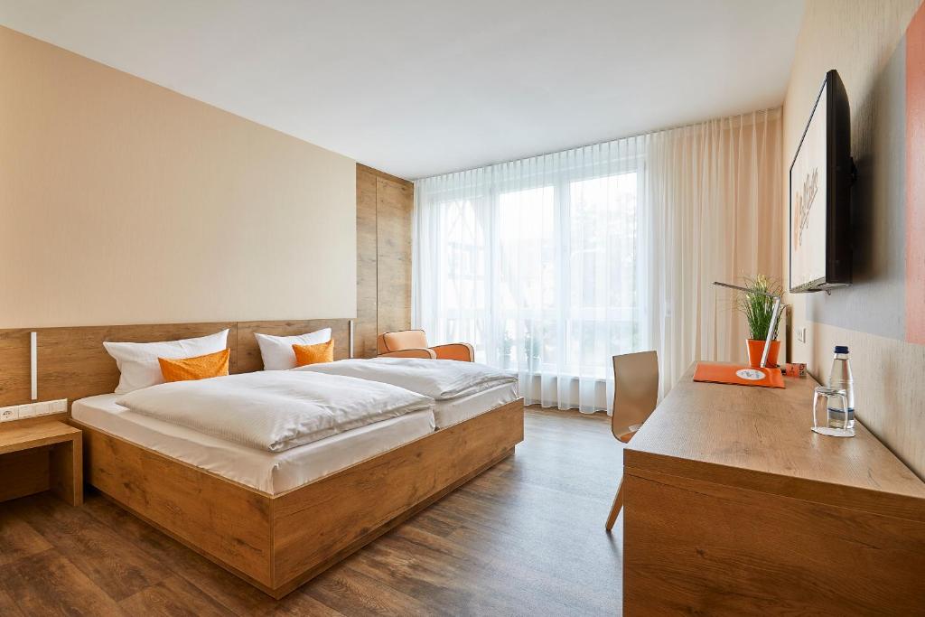 ein Schlafzimmer mit einem großen Bett und einem TV in der Unterkunft Hotel Goll in Niefern-Öschelbronn