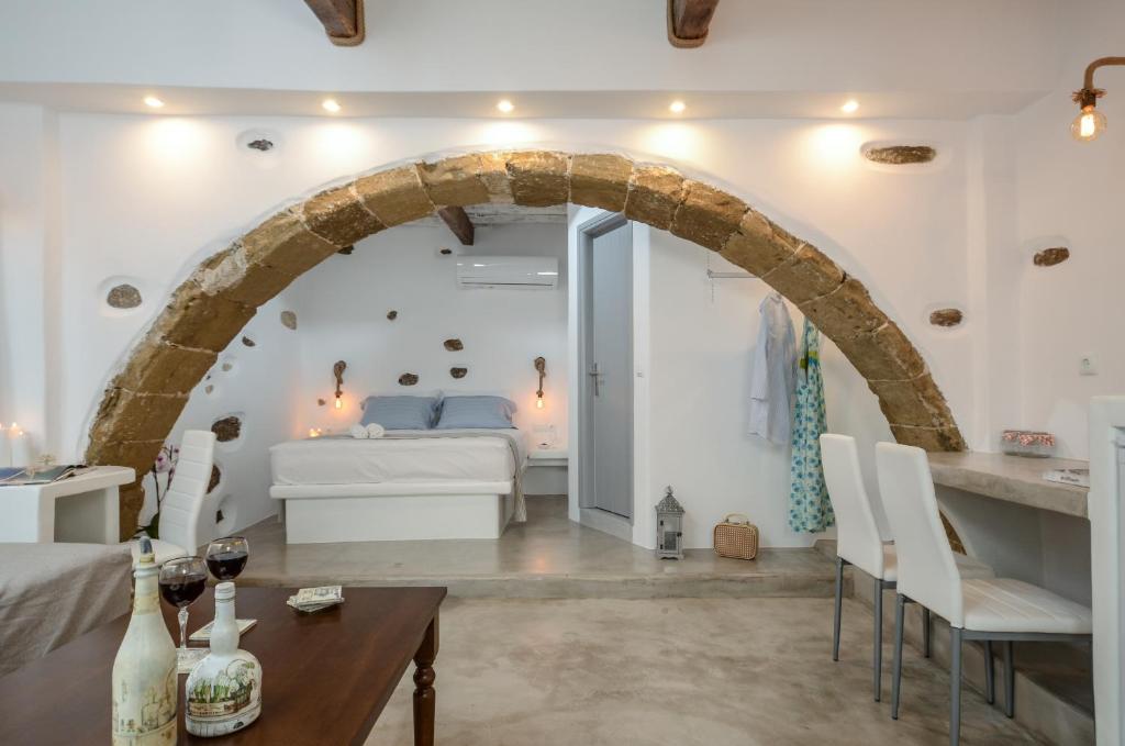 Schlafzimmer mit einem Bett, einem Tisch und Stühlen in der Unterkunft Venetian Suites in Naxos Chora