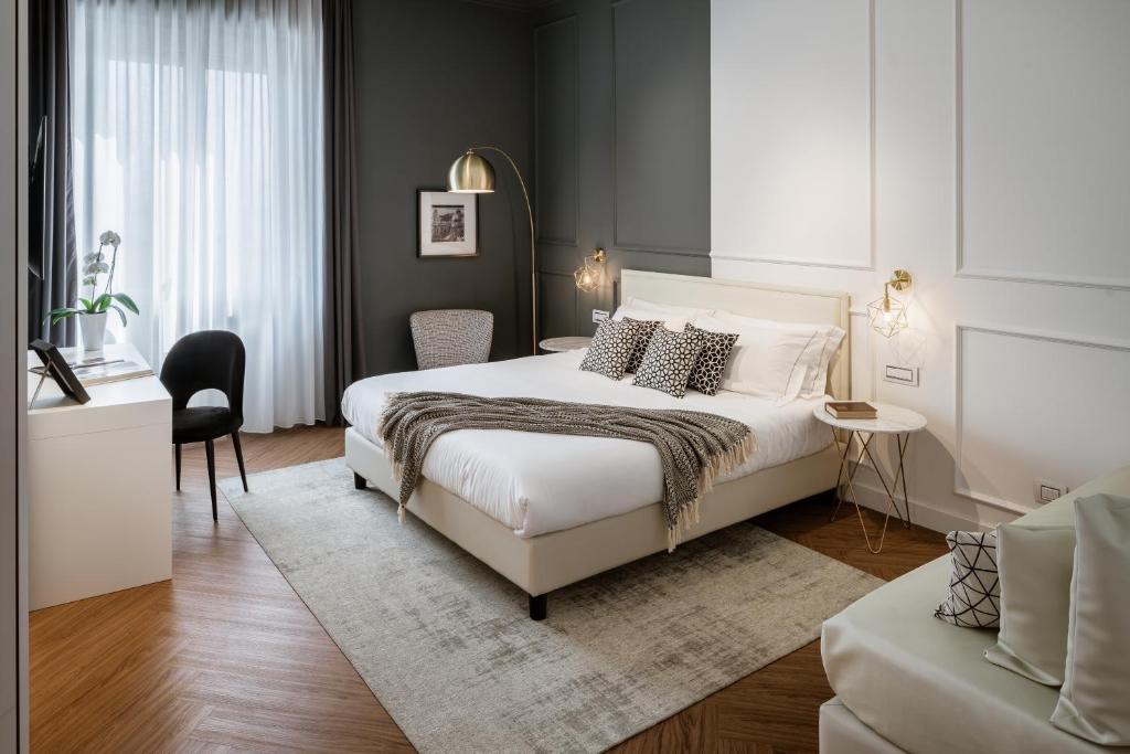 una camera con un letto bianco e una sedia di Birkin Marina a Cagliari