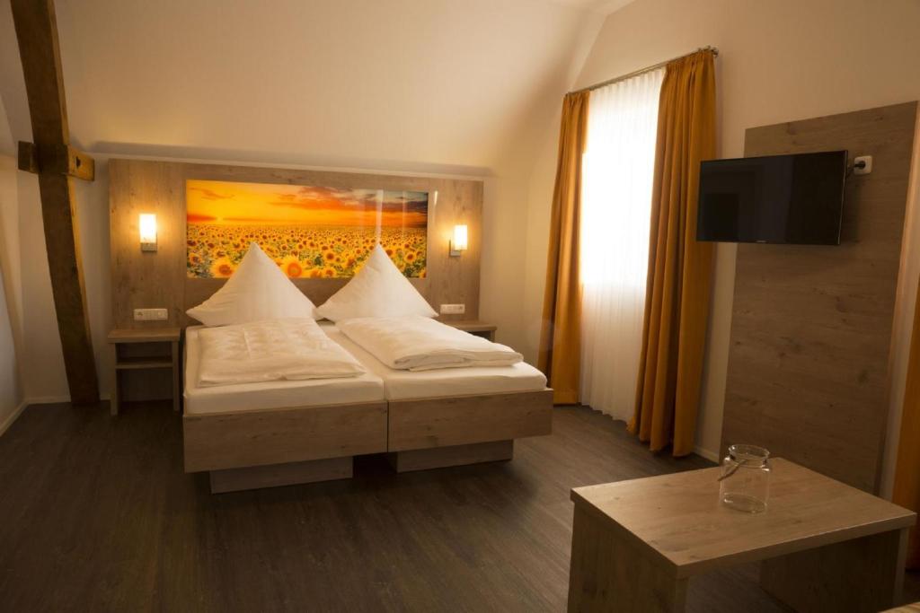 1 dormitorio con 1 cama con una pintura en la pared en Gasthaus Schwarzer Adler en Colmberg