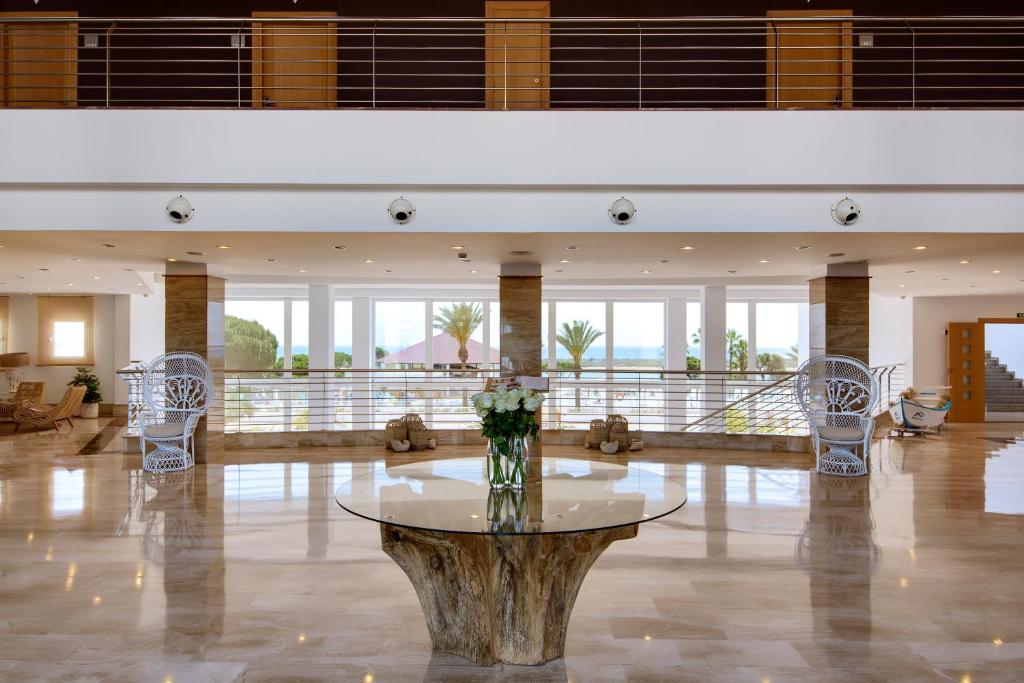 a lobby with a table with a vase of flowers at Garden Playanatural - Adults Only in El Rompido