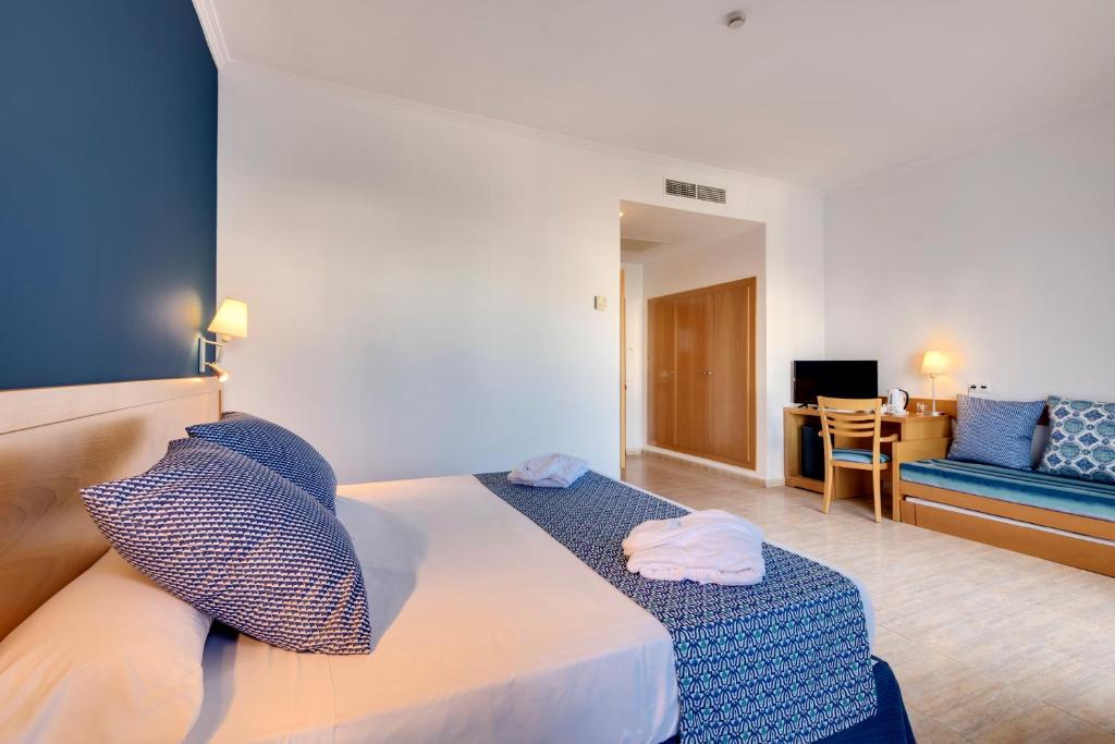 a bedroom with a bed and a couch and a table at Garden Playanatural - Adults Only in El Rompido