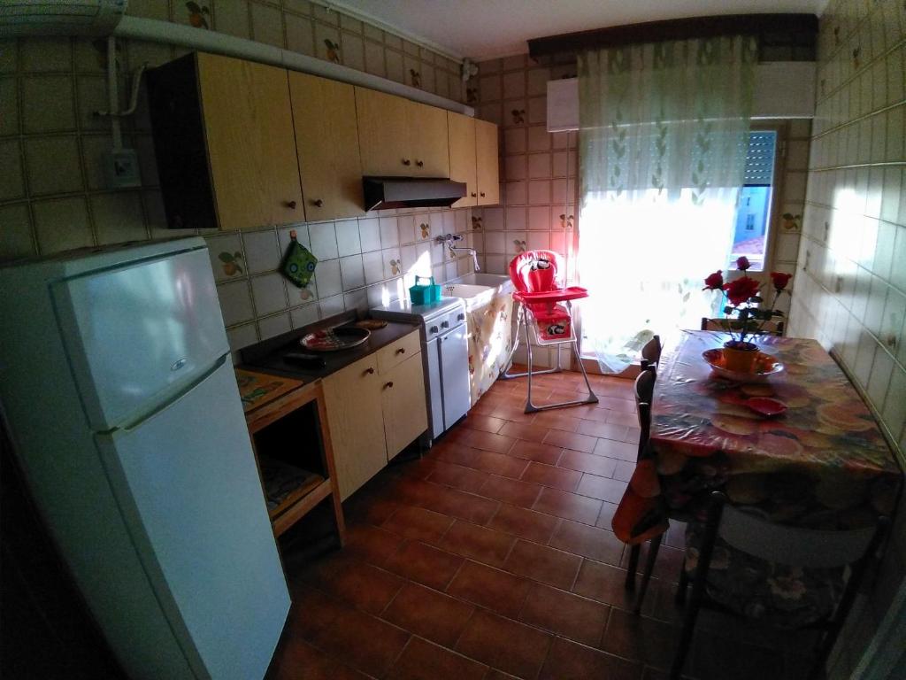 eine kleine Küche mit einem Tisch und einem Kühlschrank in der Unterkunft Appartamenti Padoan in Sottomarina