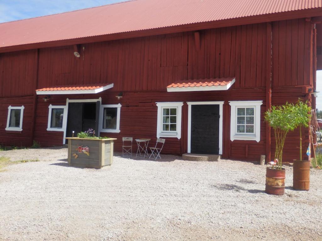 un granero rojo con ventanas blancas y sillas exteriores en Stallet B&B, en Köping