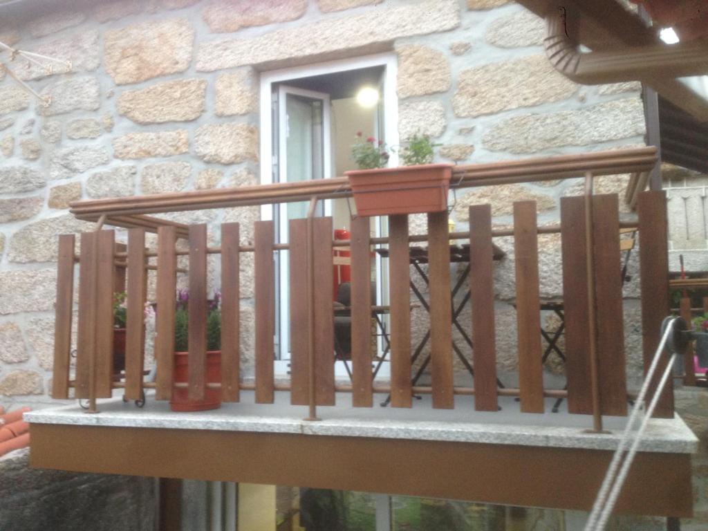 a balcony with a wooden rail and a window at Casa de Bairros in Soajo