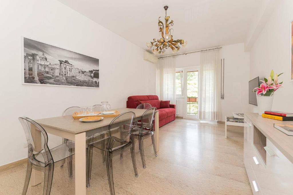 a dining room with a table and chairs and a red couch at Ad Astra Suite in Rome