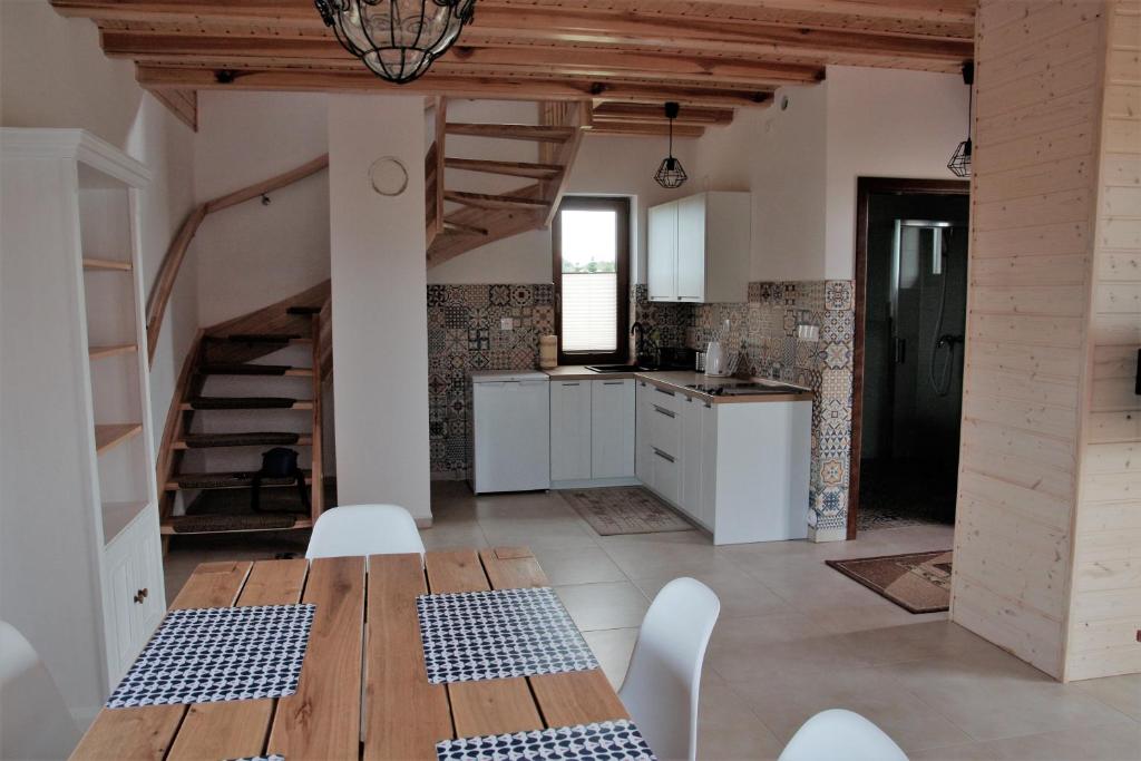 a kitchen and dining room with a table and chairs at Wygodny murowany domek- NOWY in Dąbki