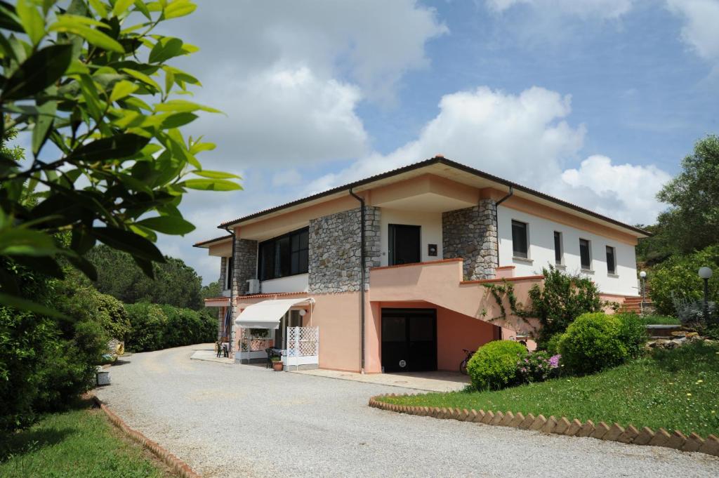 a house with a driveway in front of it at Appartamenti Serenity - 2 posti auto - in villa e in centro in Marina di Campo