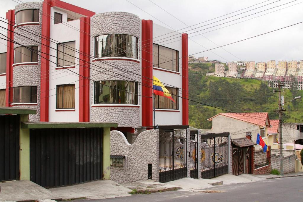 a building with red columns and a fence in front of it at ChezElena suites & apartments in Quito