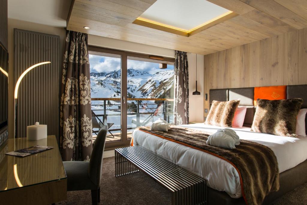 a hotel room with a bed and a large window at Hôtel Taj-I Mah by Les Etincelles in Arc 2000
