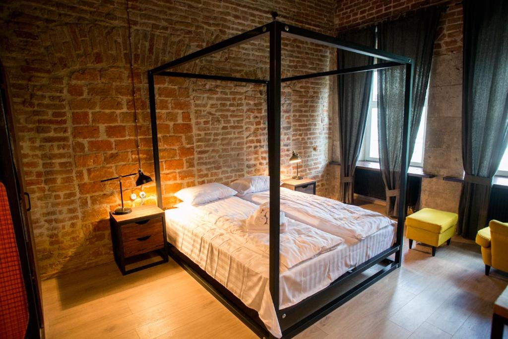 a bedroom with a canopy bed in a brick wall at Apartments JustLvivIt at the Rynok Square in Lviv