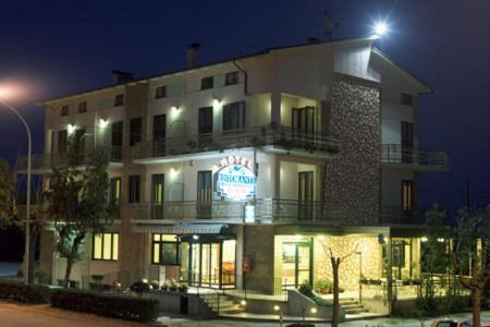 a large building with a sign on it at night at Hotel Rivamare in Massignano