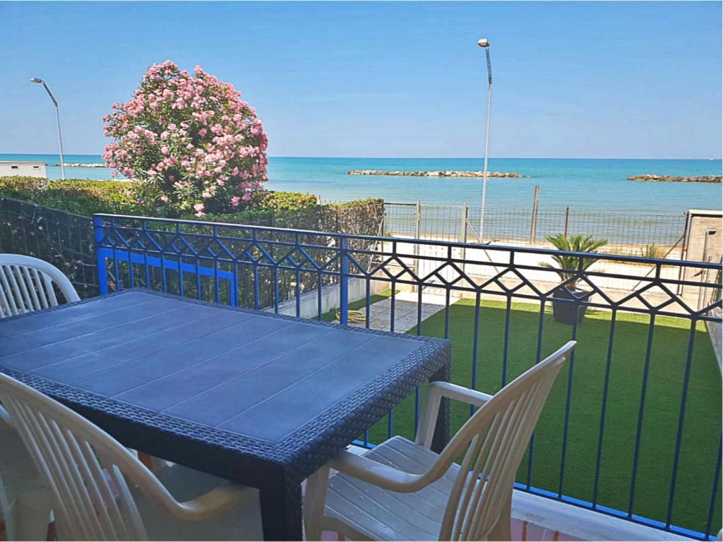 a blue table and chairs on a balcony with the ocean at Appartamento Emilia in Cupra Marittima