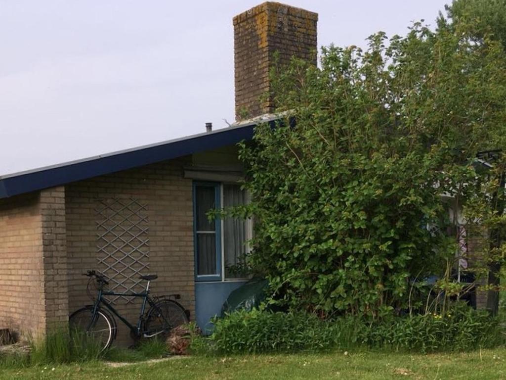 een fiets geparkeerd buiten een bakstenen huis bij Hygge House Nr. 413 in Andijk