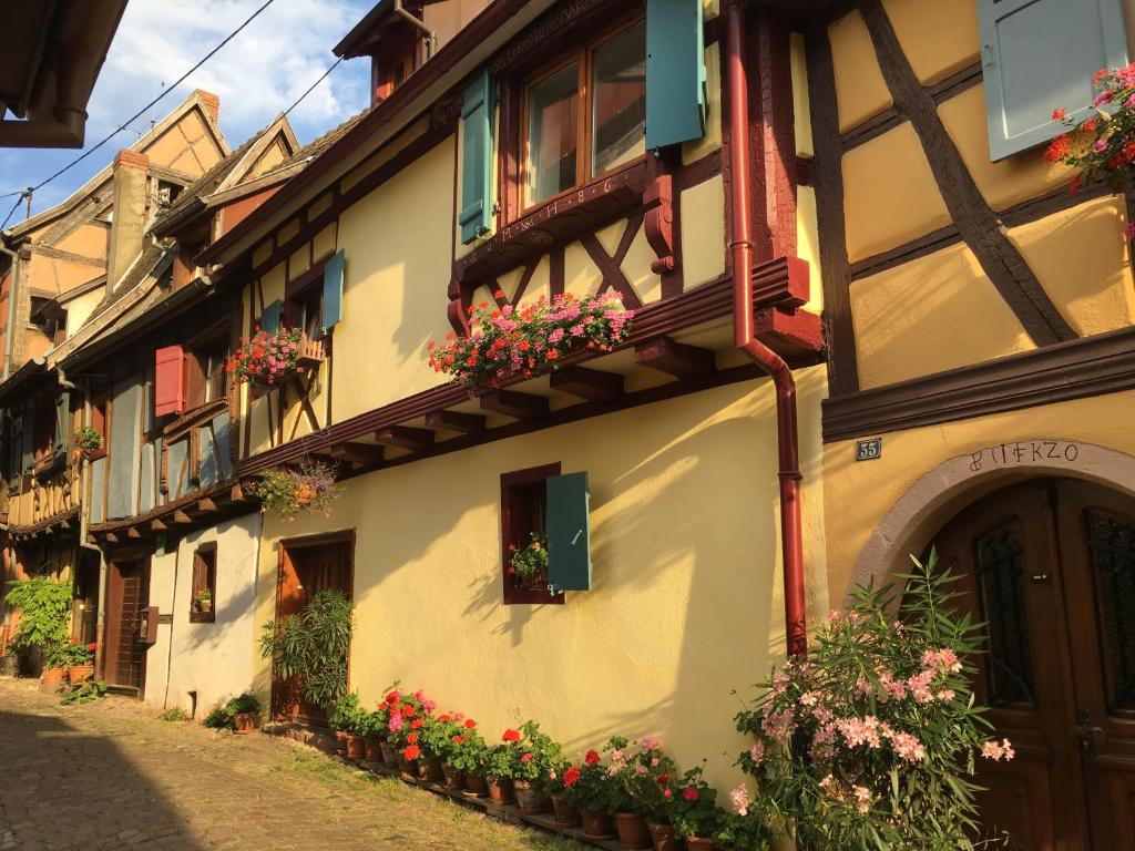 a building with flowers on the side of it at notre maison à Eguisheim in Eguisheim