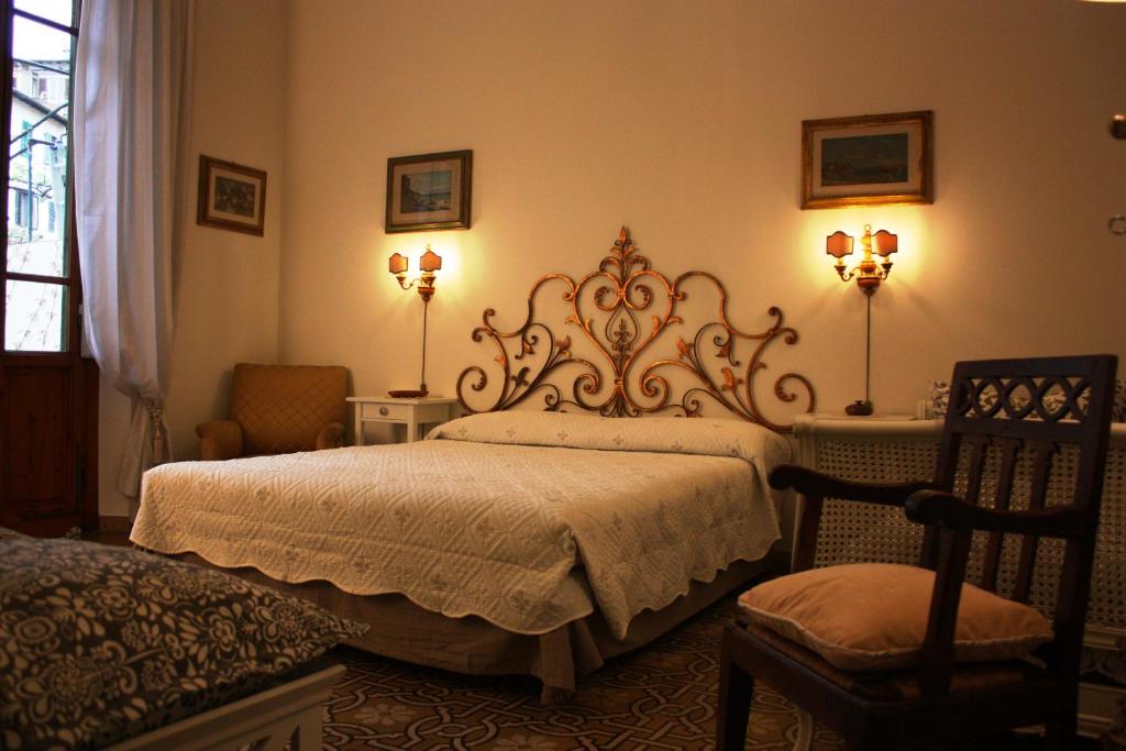 1 dormitorio con 1 cama, 2 lámparas y 1 silla en Rooms by Anna, en Florencia