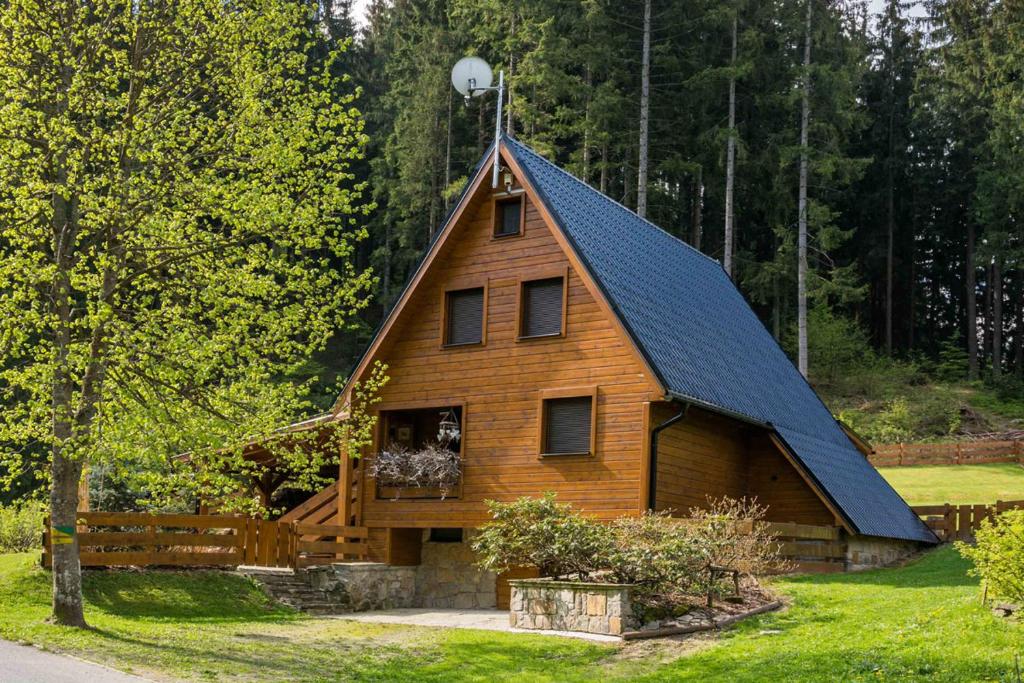ein Haus mit einem Gamer-Dach und einer Veranda in der Unterkunft U Justina Chaloupka in Velké Karlovice