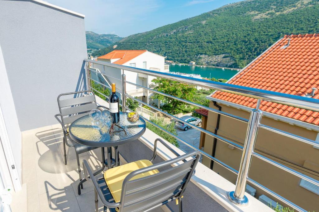 einen Balkon mit einem Tisch und Stühlen sowie Aussicht in der Unterkunft Guesthouse Pezo in Mokošica