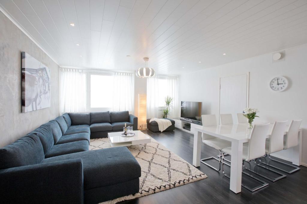 a living room with a blue couch and a white table at Arctic Suite in Rovaniemi