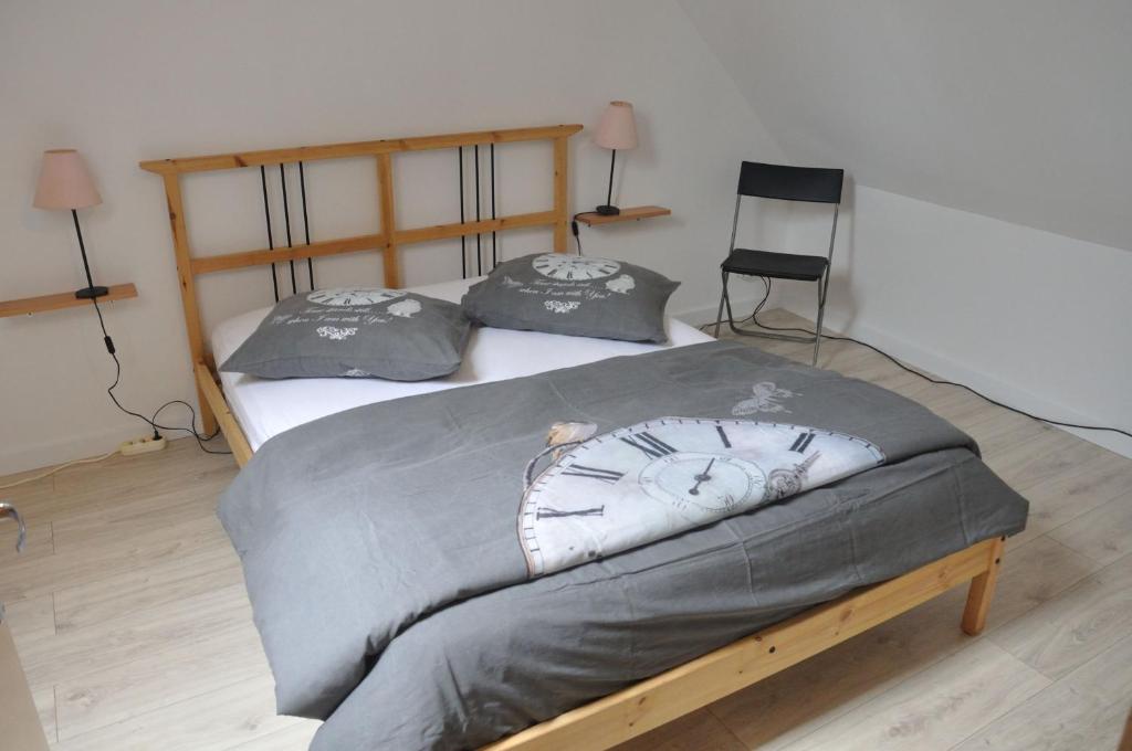 Saint-Amand-en-PuisayeにあるPetite maison aux volets bleusのベッドルーム1室(ベッド2台、時計付)