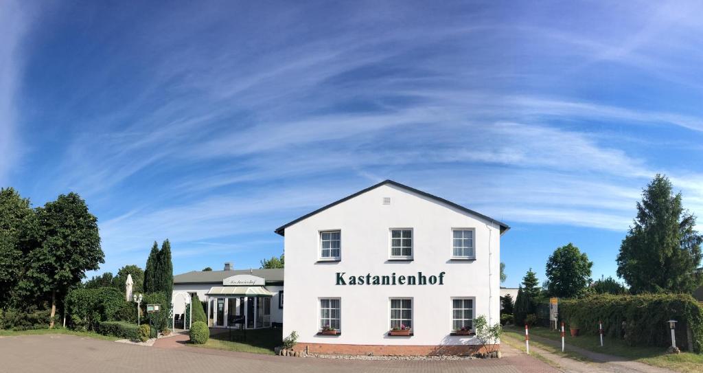 a white building with the words kashkent institution at Kastanienhof Hotel garni in Zinnowitz