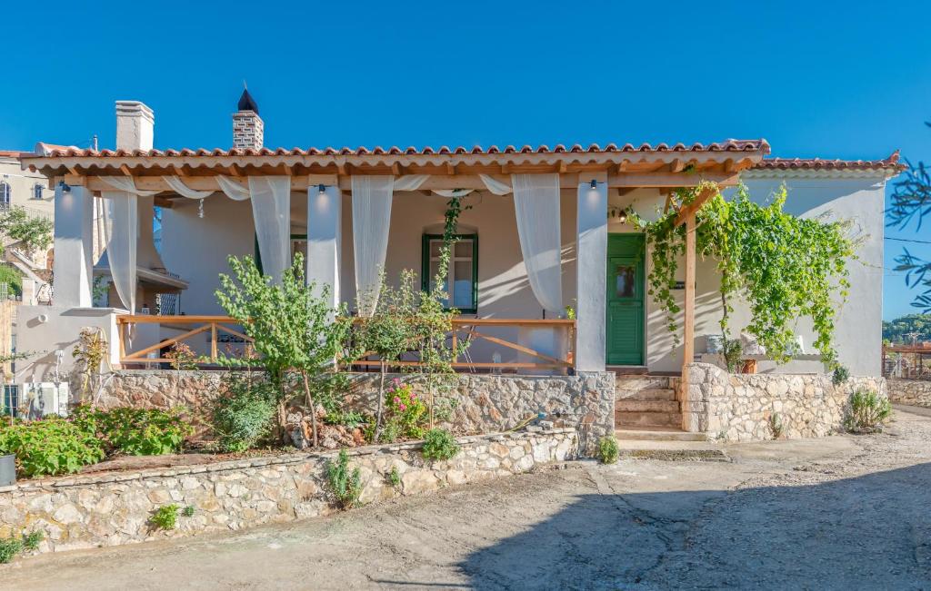 een huis met een stenen muur en een groene deur bij Sempreviva in Agios Leon