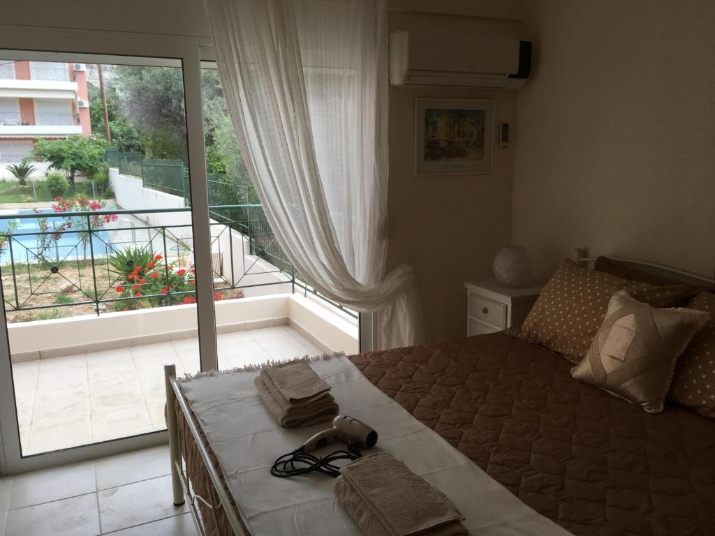 een slaapkamer met een bed en een groot raam bij Lovely Appartments Lygia Korinthias in Liyiá