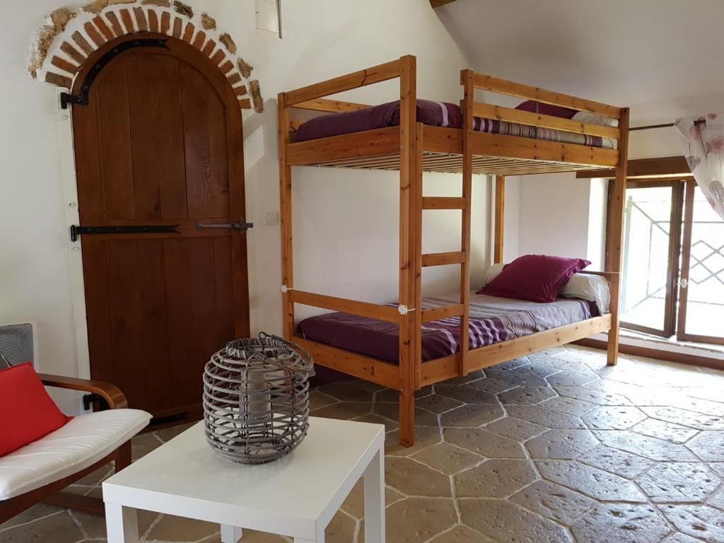 Zimmer mit 2 Etagenbetten und einem Tisch in der Unterkunft La Montagne de Bellot in Bellot