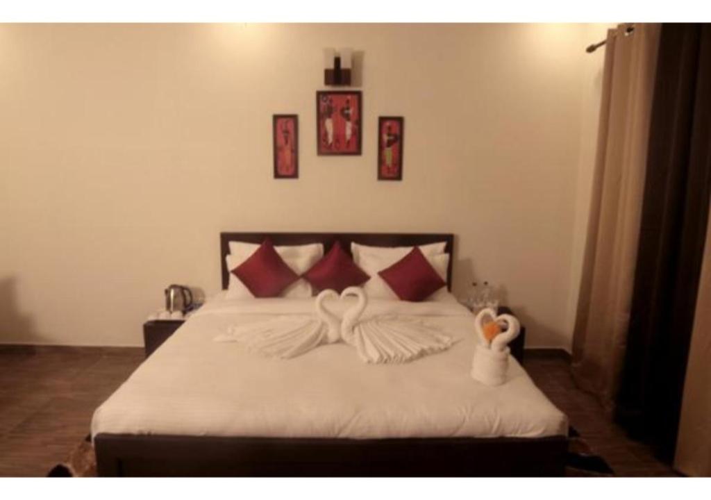 a bedroom with a bed with red and white pillows at Riverside Resort in Lap of Nature in Nainital