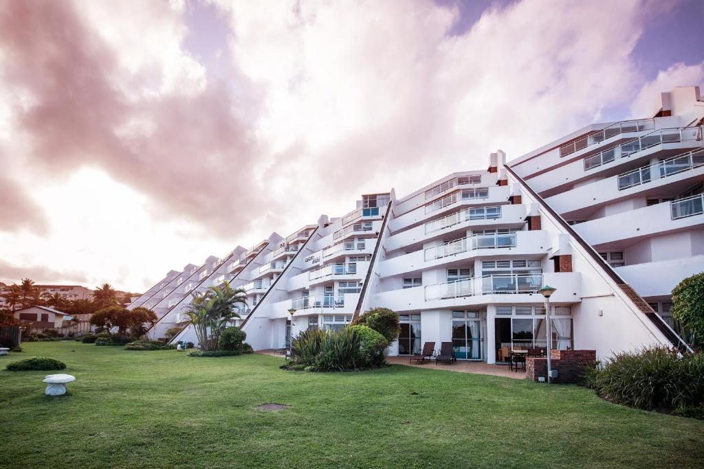 馬蓋特的住宿－First Group La Cote D'Azur，一排带绿色庭院的白色公寓楼