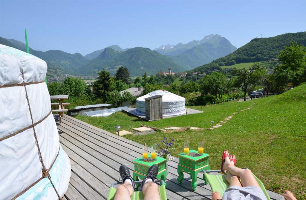 une personne posant sur un pont avec ses pieds en haut dans l'établissement Yourtes Olachat proche Annecy, à Faverges