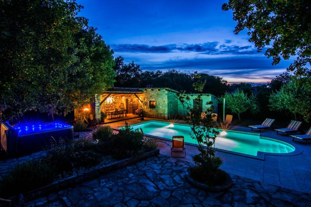 - une piscine dans un jardin la nuit dans l'établissement Apartments Angela 1711, à Rakalj