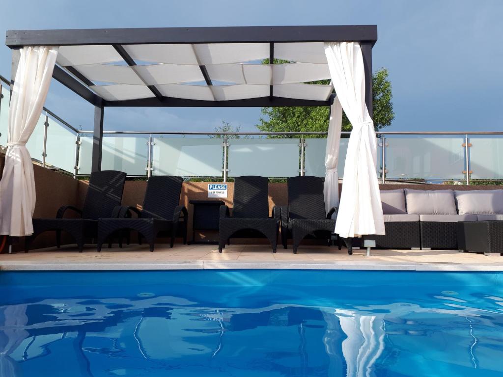 un patio con mesa y sillas junto a una piscina en Apartments Melon Vodice, en Vodice