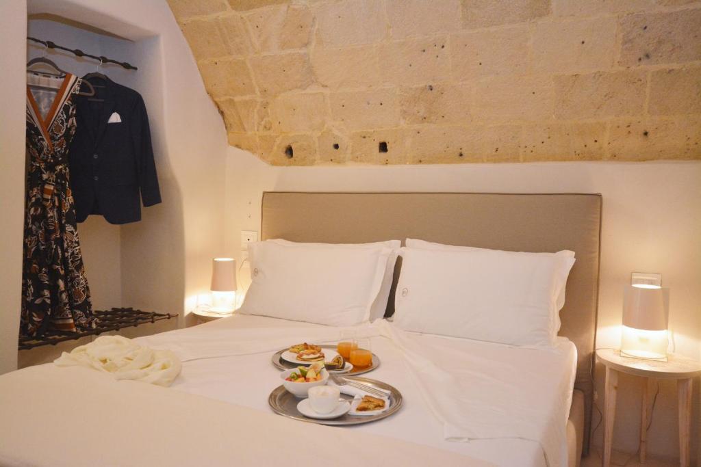 a white bed with a tray of food on it at I Bastioni San Domenico - Boutique Hotel in Gallipoli