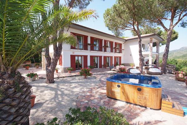 Casa grande con bañera de hidromasaje frente a ella en Villa Capitorsola en Capoliveri